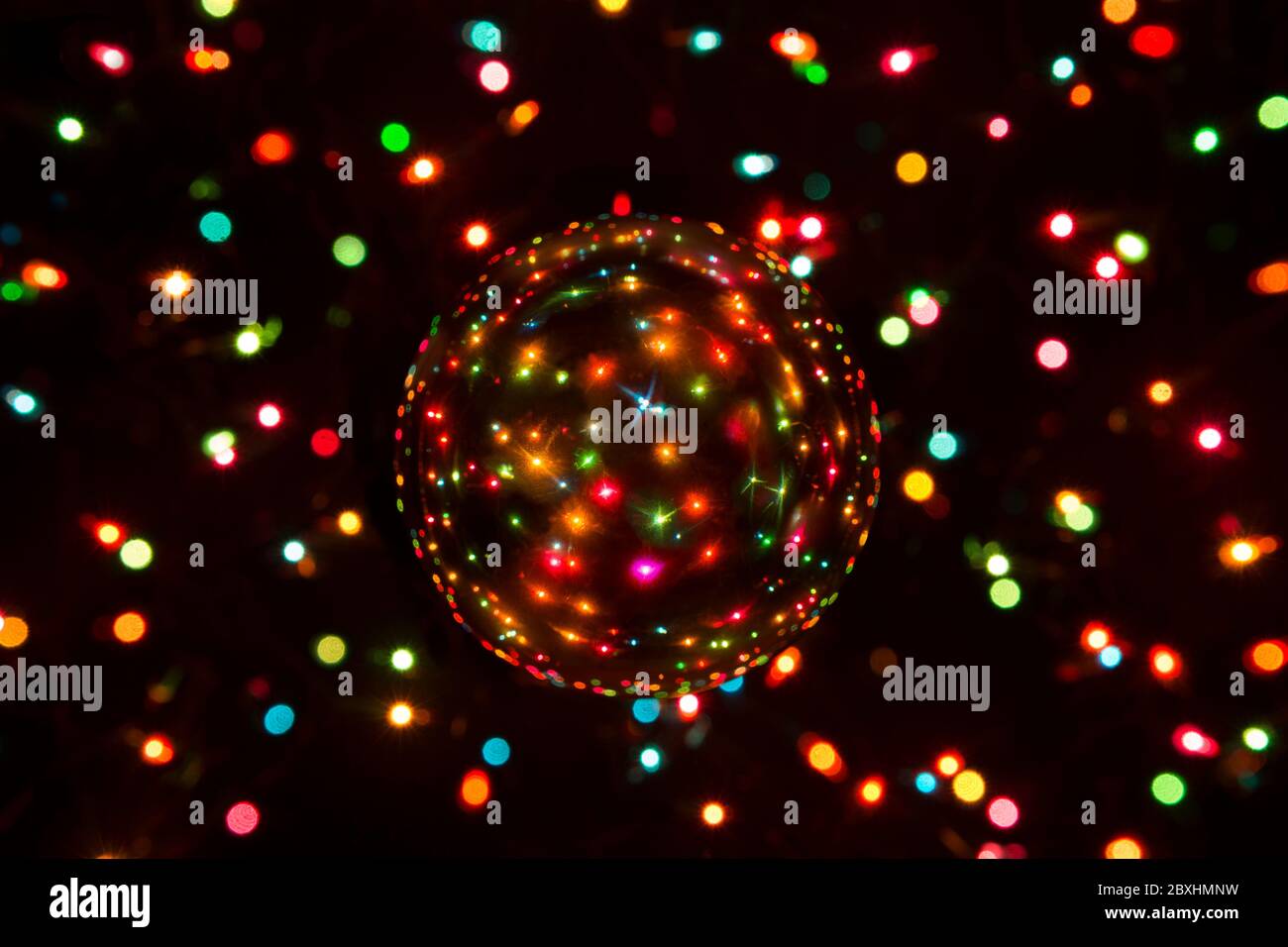 Des lumières de Noël qui brillent à travers une boule de cristal Banque D'Images
