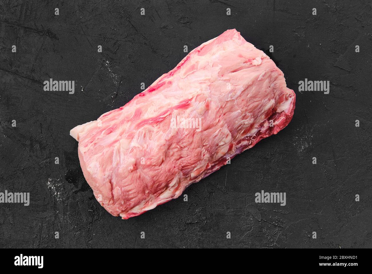 Viande de porc fraîche crue sur fond noir, vue du dessus Banque D'Images
