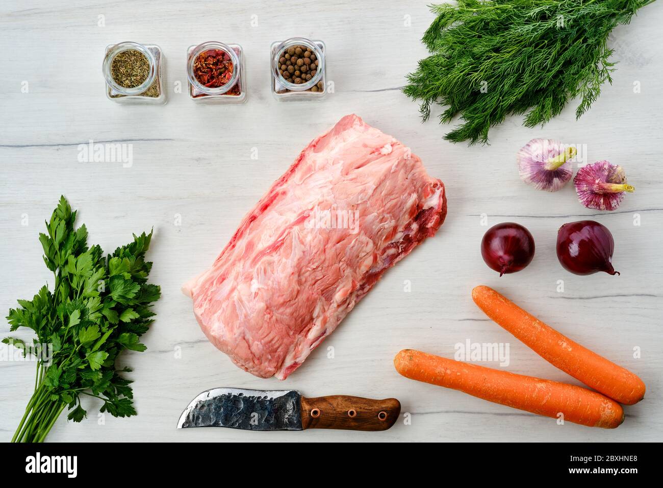 Viande de porc fraîche crue sur fond de bois avec épices, vue du dessus Banque D'Images