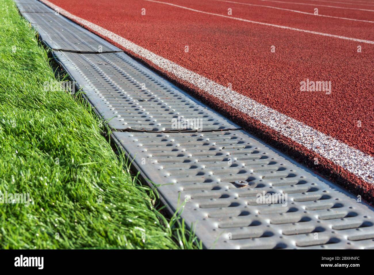 La frontière entre le terrain de football et le tapis roulant dans le stade  de sport sous forme de caniveau. Vidange de l'eau dans le stade Photo Stock  - Alamy
