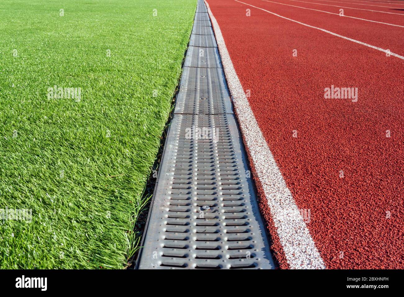 La frontière entre le terrain de football et le tapis roulant dans le stade  de sport sous forme de caniveau. Vidange de l'eau dans le stade Photo Stock  - Alamy