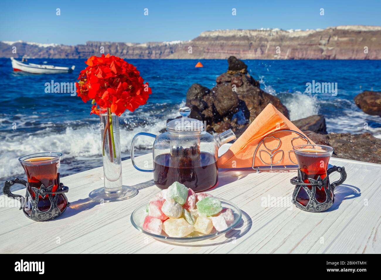 Thé et bonbons sur la plage sur fond de la vague de mer Banque D'Images