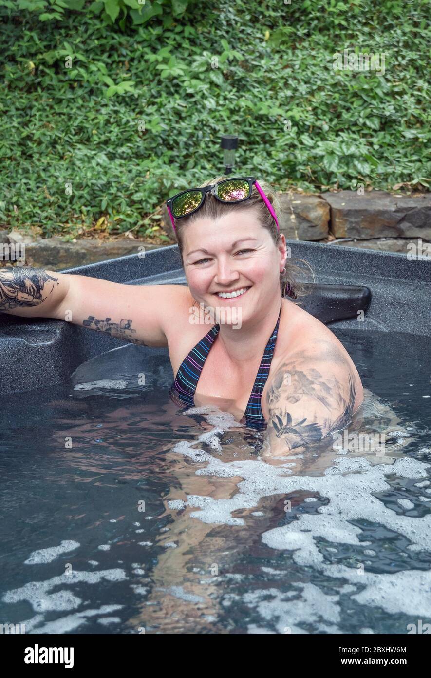 femme de race blanche se relaxant dans un bain à remous extérieur Banque D'Images