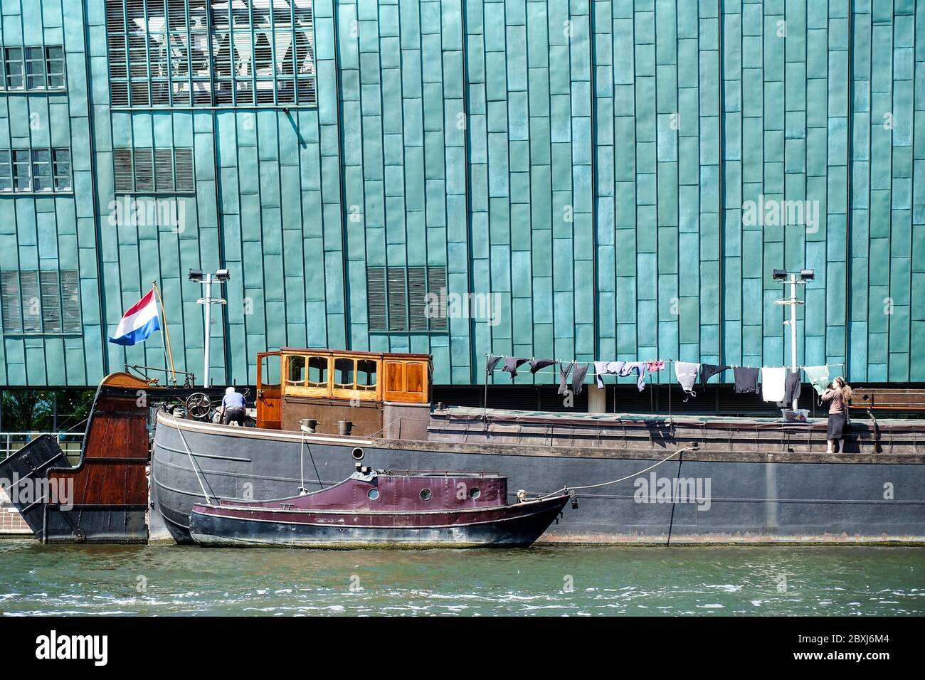Nemo musée à Amsterdam, avec un bateau passant, un drapeau hollandais et un propriétaire de péniche séchage de blanchisserie Banque D'Images