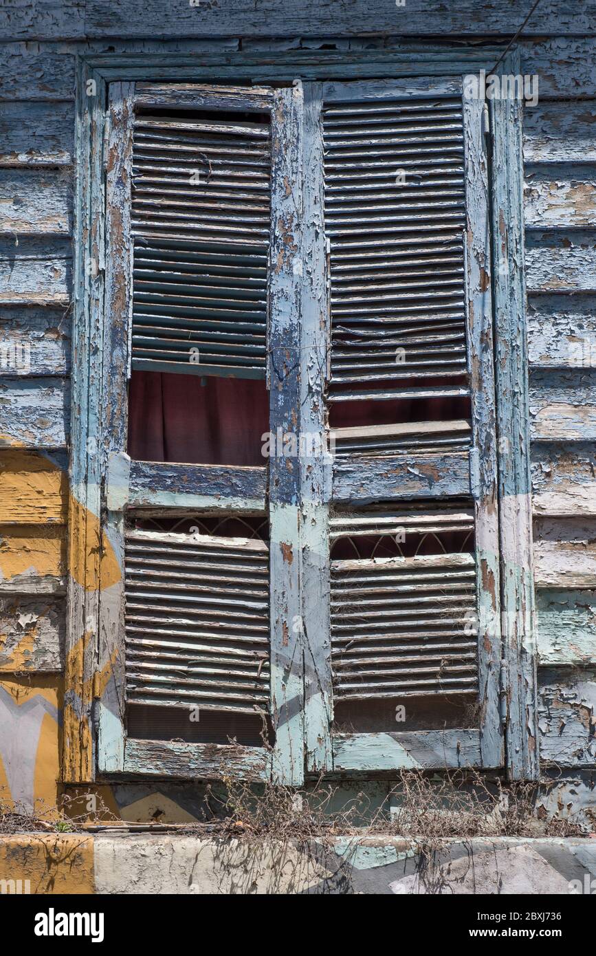 Une fenêtre avec volets dans un bâtiment abandonné dans le quartier de la Boca à Buenos Aires, en Argentine, en Amérique du Sud Banque D'Images