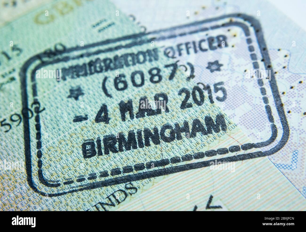 Timbre d'entrée sur passeport délivré par un agent d'immigration aux frontières et contrôle des visas à l'aéroport de Birmingham au Royaume-Uni. Mise au point sélective. Photo macro. Banque D'Images