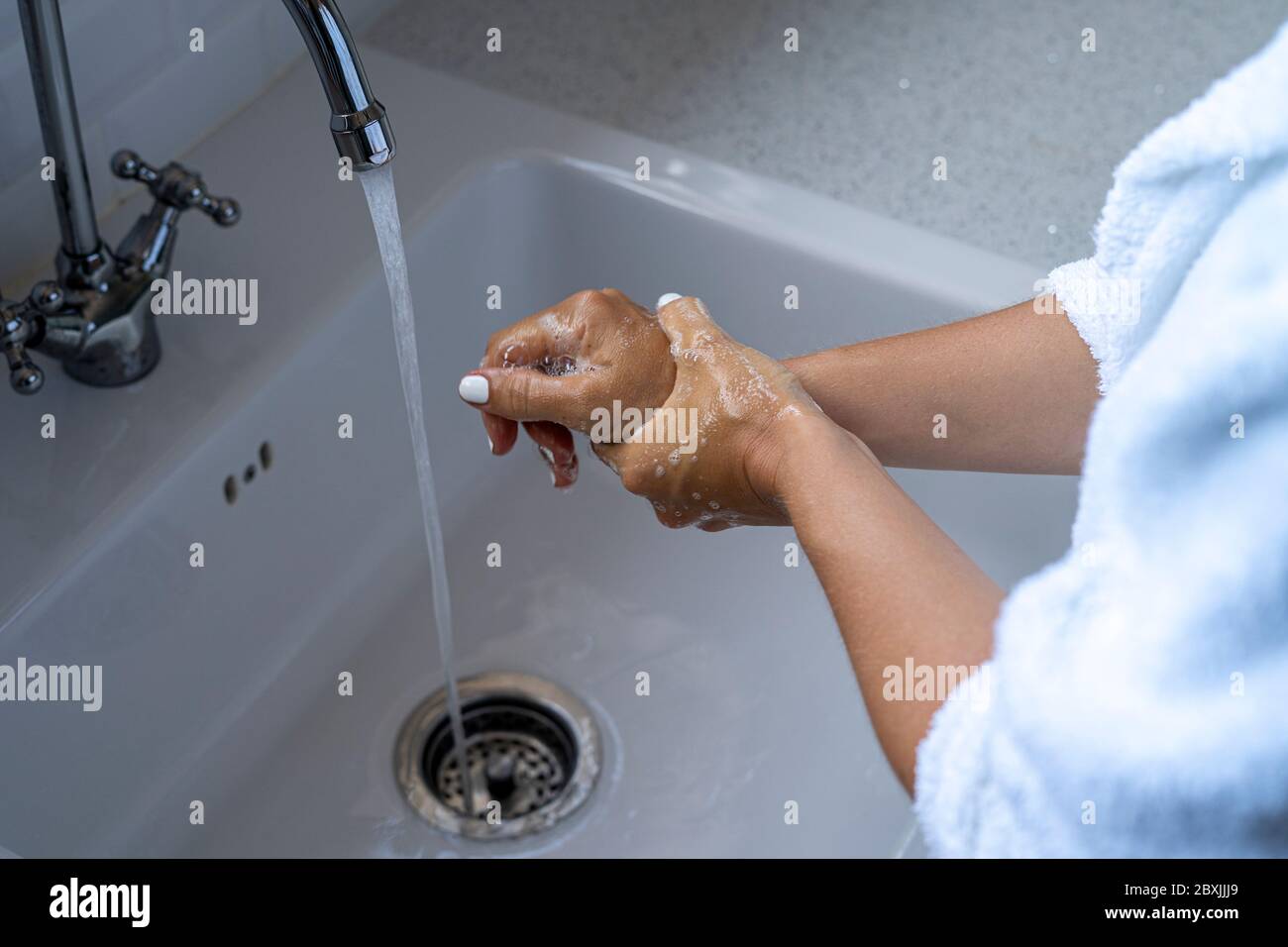 Lavez-vous les mains. Une femme se lavant les mains avec du savon pour réduire le risque d'infection par le covid-19. Banque D'Images