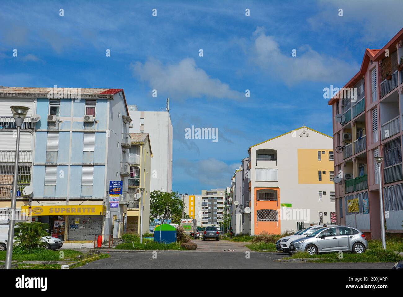 Point-a-Pitre, Guadeloupe - 17 sept. 2018: Rue avec immeubles modernes et colorés, une boutique et des voitures garées en Guadeloupe. Copier l'espace Banque D'Images