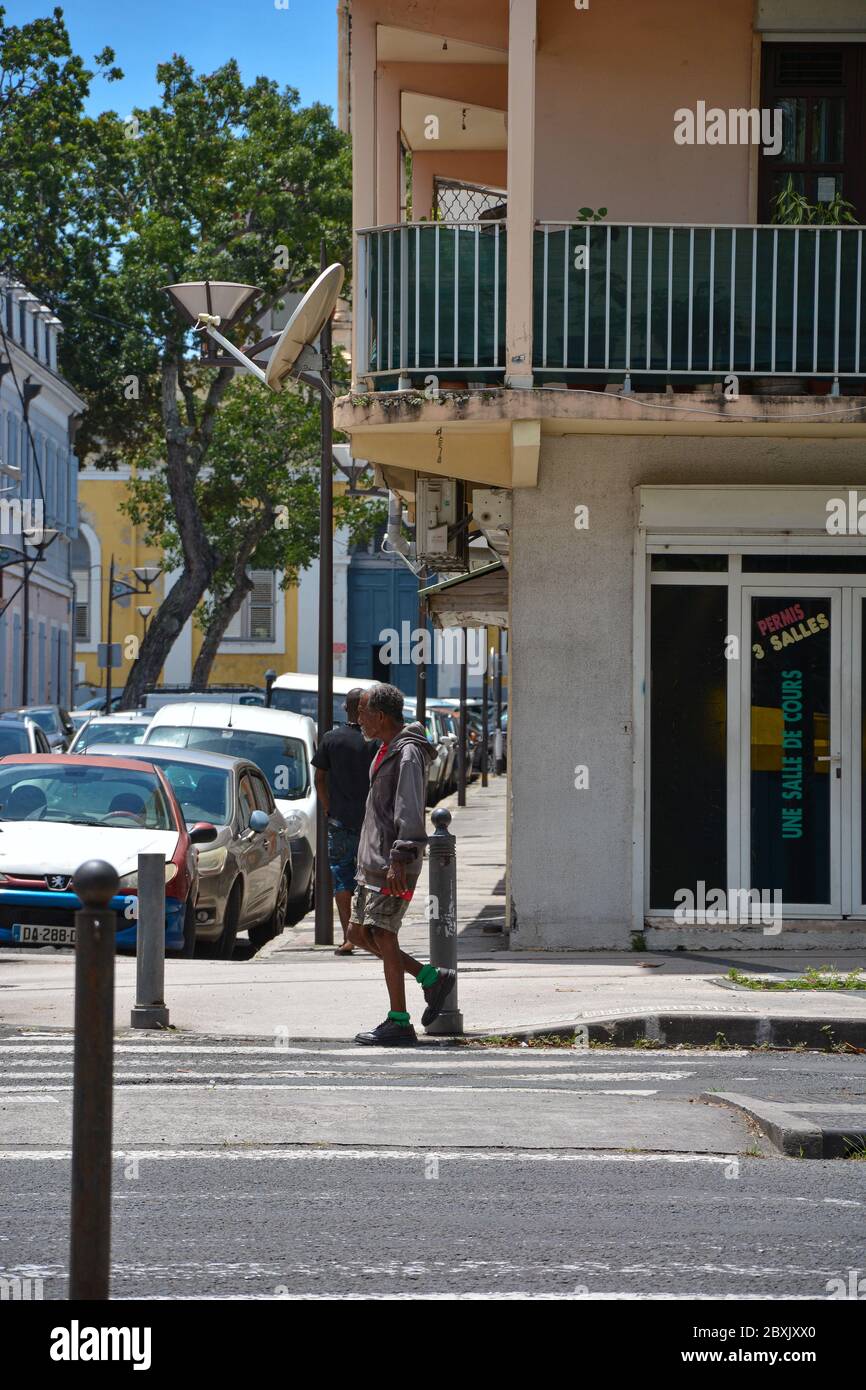 Point-a-Pitre, Guadeloupe - 17 septembre 2018 : un homme sans domicile vêt de vêtements sales à la tête grise descend dans la rue dans un chandail, un short, une basket Banque D'Images