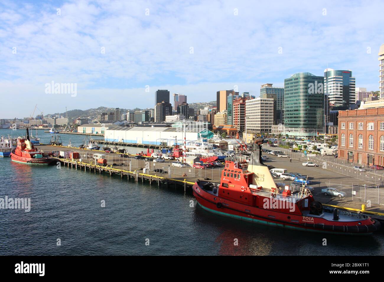 WELLINGTON, NOUVELLE-ZÉLANDE - 16. JANVIER 2014: Infrastructure portuaire à Wellington avec plusieurs navires - remorqueurs, bateaux de pêche, ferry et bâtiments. Banque D'Images