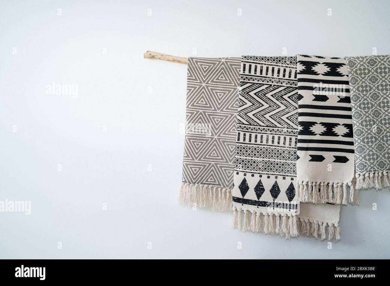 Tapis stylés et artistiques accrochés à un bâton de bois.Décoration sur le mur d'une maison Banque D'Images