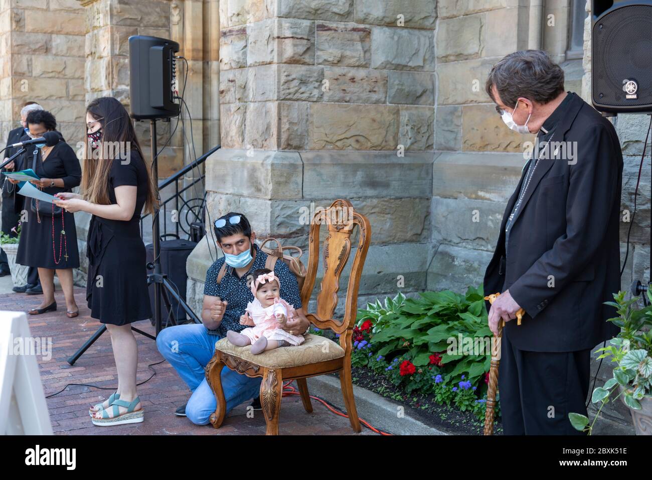Detroit, Michigan, États-Unis. 7 juin 2020. L'archevêque catholique de Detroit Allen Vigneron (à droite) a dirigé un rosaire pour la justice raciale à l'extérieur de Sainte-Anne Basilique Anne. Tenue par son père Bernardo Conteras, Julietta Contreras, 10 mois, a eu l'occasion de s'asseoir sur la chaise de l'archevêque pendant que sa mère Janet Contreras a lu le second mystère. L'événement a eu lieu après deux semaines de protestations au sujet du meurtre par la police de George Floyd à Minneapolis. Les paroissiens présents ont été invités à pratiquer la distanciation sociale et à porter des masques en raison de la pandémie du coronavirus. Crédit : Jim West/Alay Live News Banque D'Images