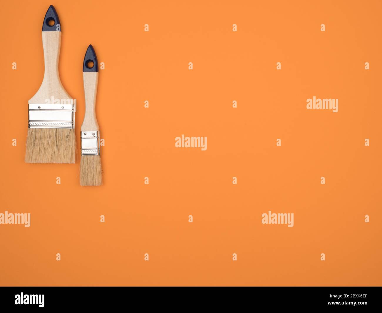 Brosse pour travaux de peinture. Arrière-plan orange. Banque D'Images