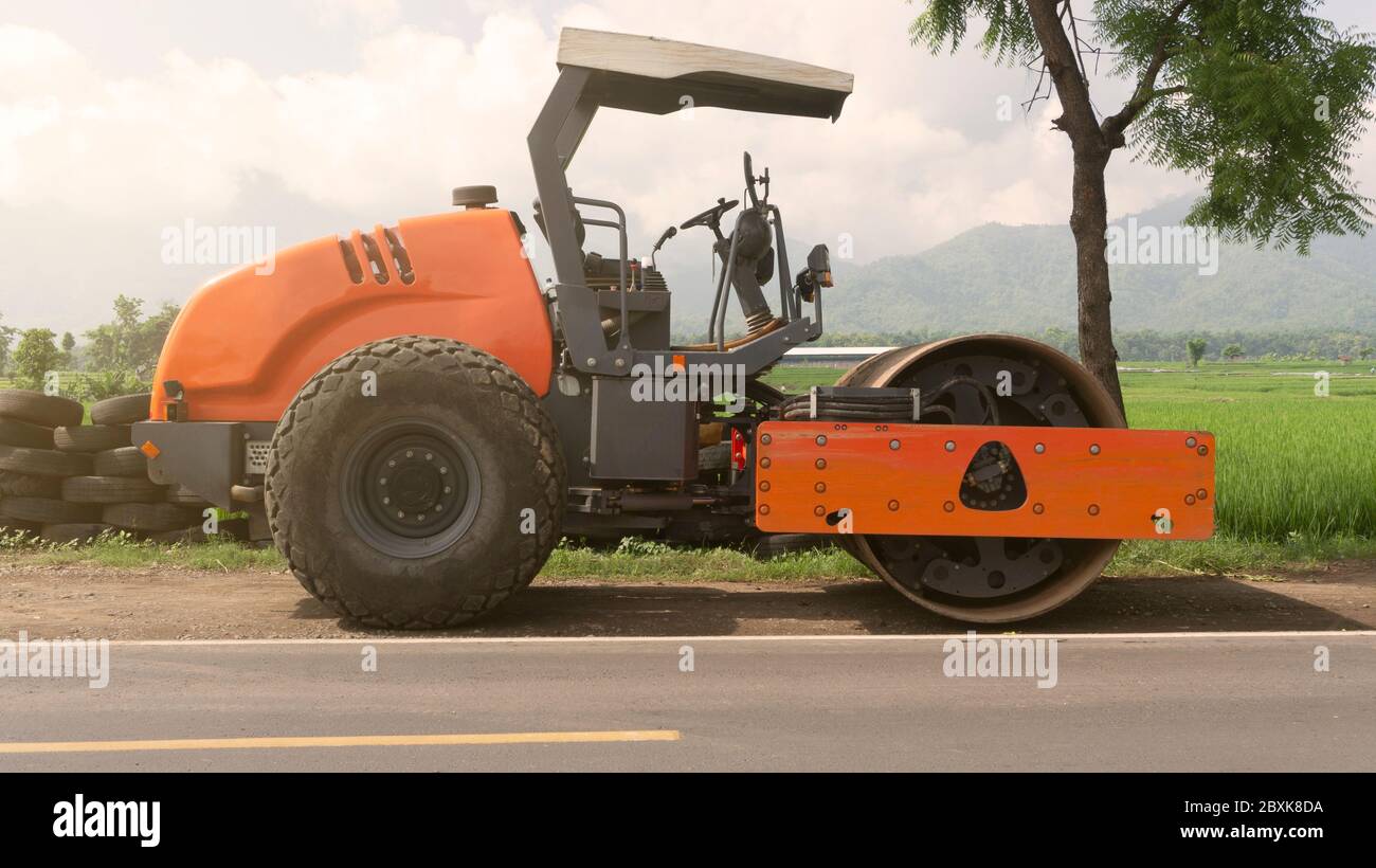 Vibration rouleau de route à cylindre unique nivelant le sol pour la fondation. Compacteur de sol pour la pose d'asphalte sur route sur le chantier de construction. Communication routière Banque D'Images