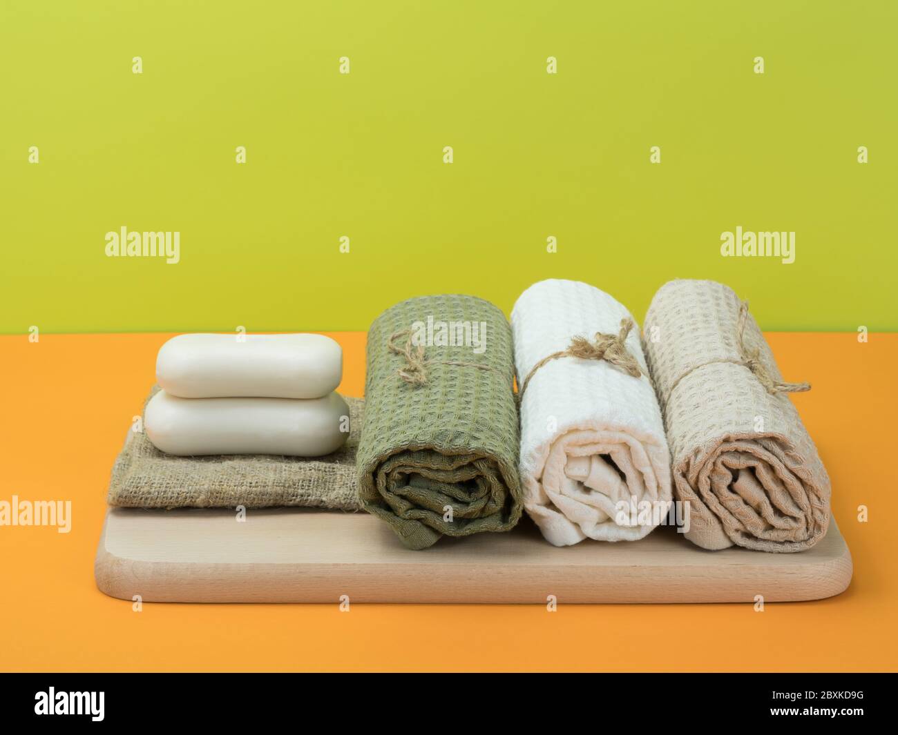 Savon et serviette de style écologique avec fond orange et vert. Banque D'Images