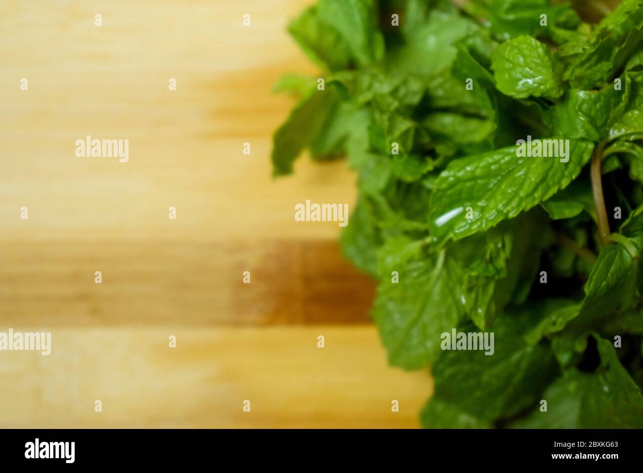 Un bouquet de feuilles de menthe fraîche sur une table en bois brun Banque D'Images