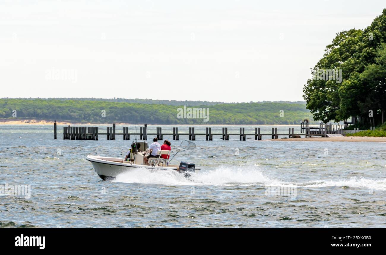 Un couple sur une console centrale de bateau arrondissant Tyndal point, North Haven, NY Banque D'Images