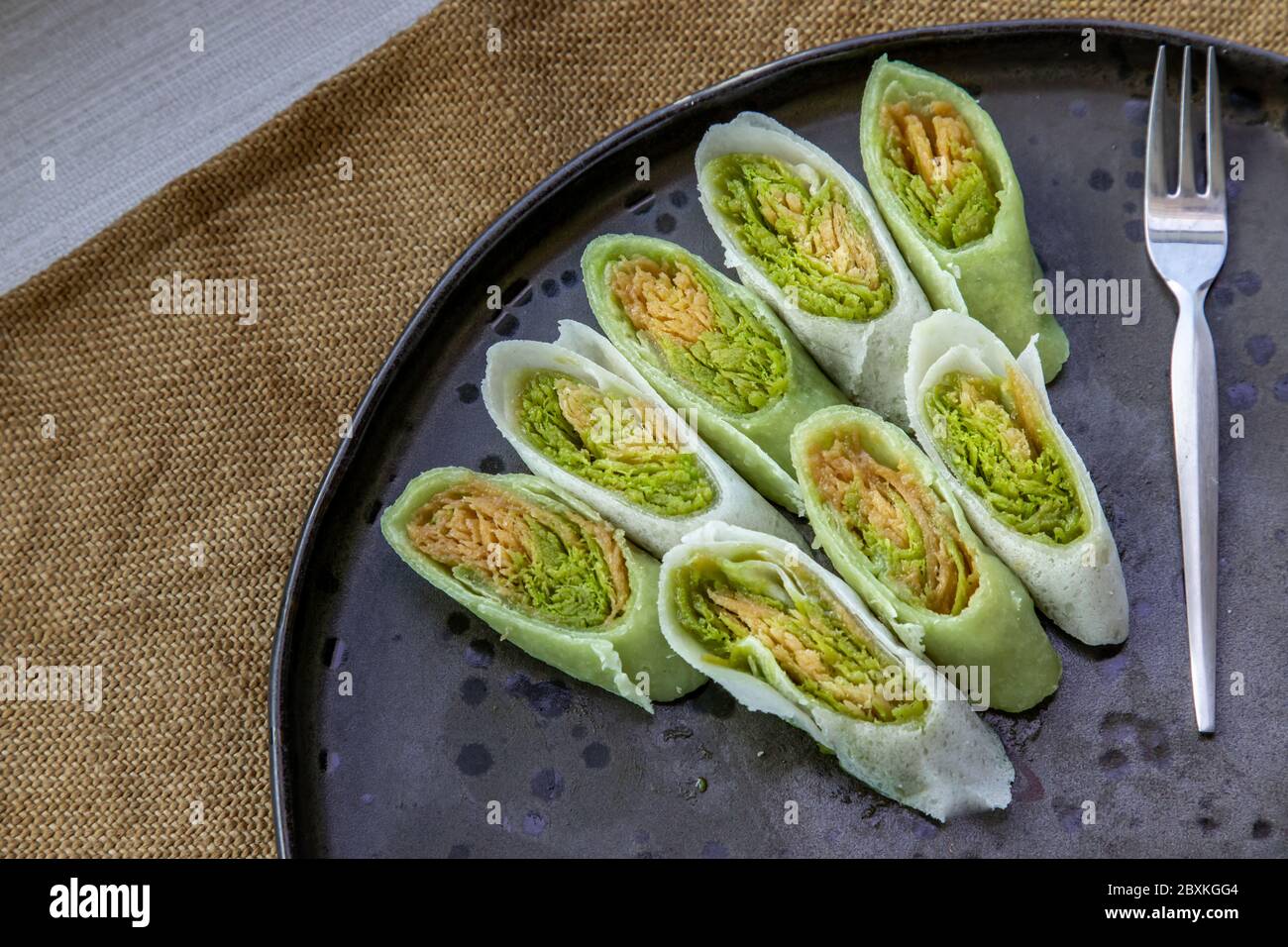 Roti Sai Mai est le nom de bonbons de coton thaïlandais enveloppés de pâte à pâtisserie coupée en fines tranches servant avec sur une assiette noire. Le fil de soie roti est un o Banque D'Images