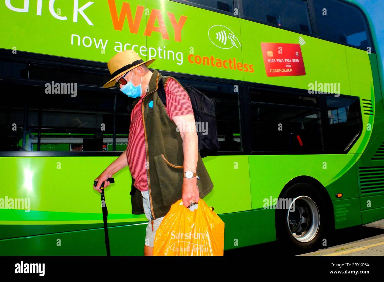 Homme âgé retraité portant un masque covid19 couvrant le visage à l'autobus Arrêt en bus à la station de bus paiement sans contact Go vert Groupe Ahead Southern Vectis Banque D'Images