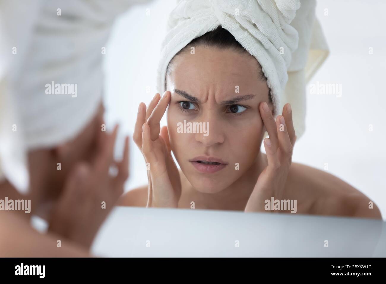 Gros plan femme malheureuse vérifiant la peau, regardant dans le miroir Banque D'Images