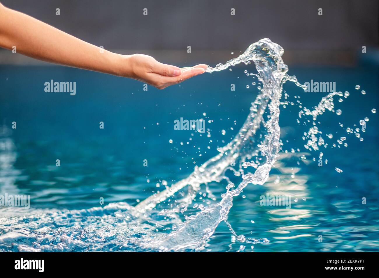 Gros plan d'une eau qui éclabousse les mains dans la piscine Banque D'Images