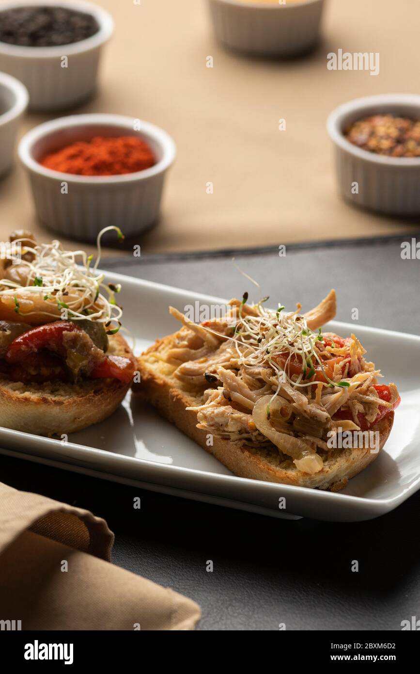 bruschetta sur plaque et tapis en cuir avec épices sur fond et serviette Banque D'Images