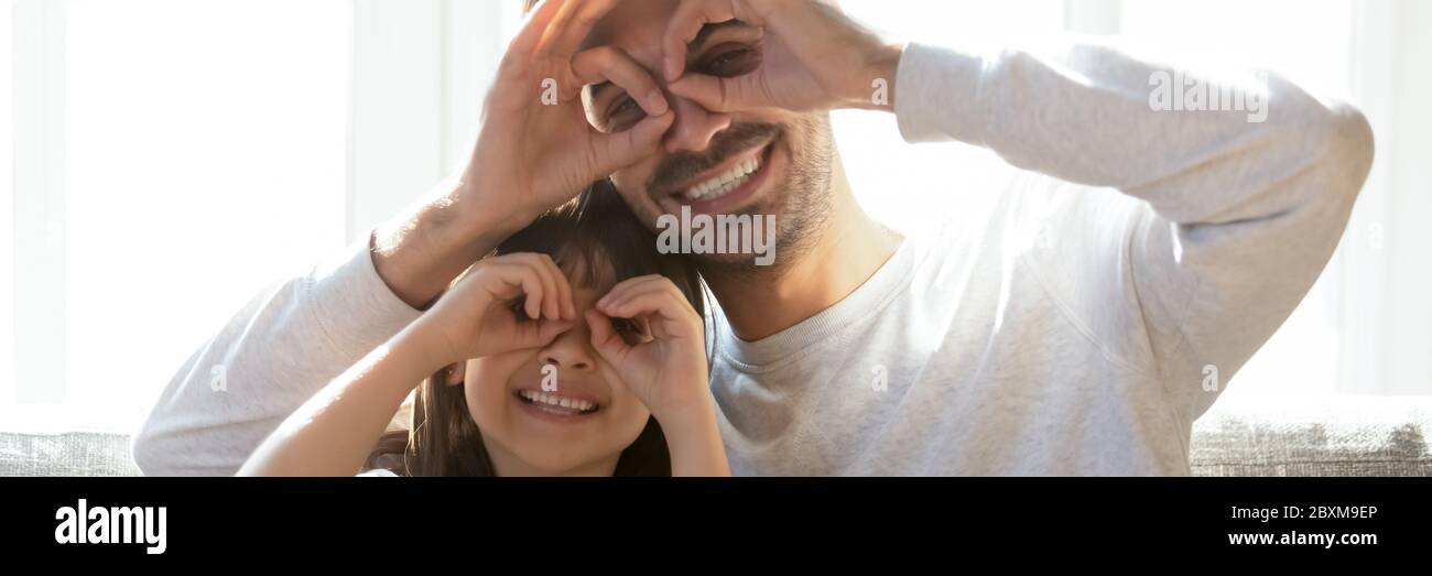 Père et fille faisant des visages drôles ayant du plaisir à la maison Banque D'Images