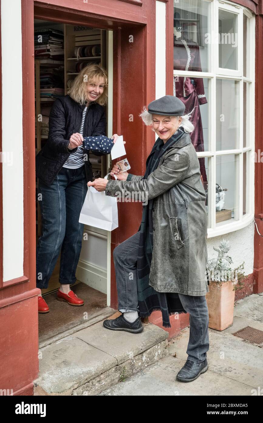 Ellie Mathieson (l), couturière de Presteigne, pays de Galles, Royaume-Uni, est en train de faire des masques élégants pour ses clients, y compris l'artiste Monica Guggisberg (r) Banque D'Images