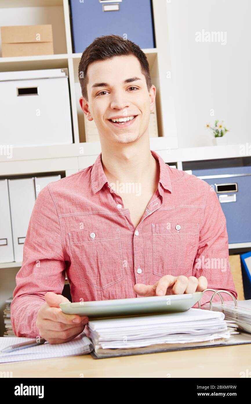 Jeune homme riant en utilisant une tablette dans le bureau Banque D'Images
