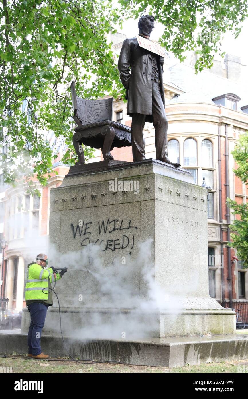 Un ouvrier nettoie les graffitis du plinthe de la statue d'Abraham Lincoln sur la place du Parlement à Londres, à la suite d'une manifestation Black Lives Matter le week-end. Une série de manifestations à travers le Royaume-Uni ont été déclenchées par la mort de George Floyd, qui a été tué le 25 mai alors qu'il était en garde à vue dans la ville américaine de Minneapolis. Banque D'Images