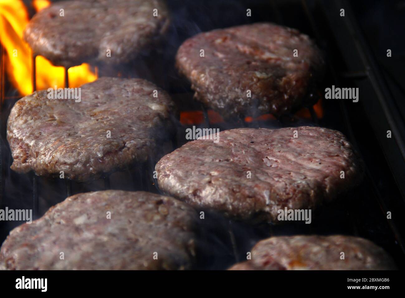 Photo des viandes de hamburger fraîches grillées au feu. Banque D'Images