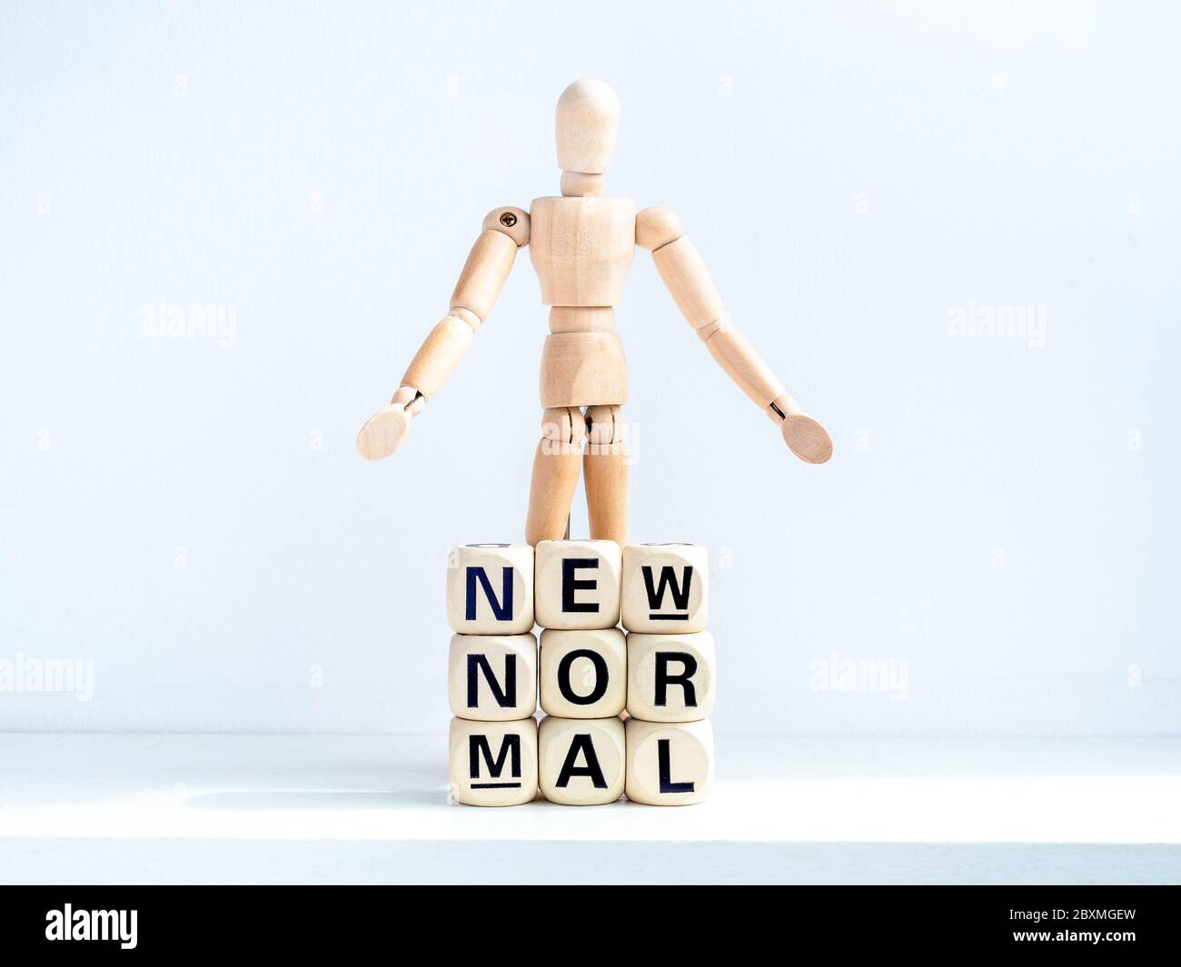 Nouveau Normal, mots sur cube alphabet bois et figure en bois sur fond blanc. Nouvelle vie normale après le concept de pandémie Covid-19. Banque D'Images