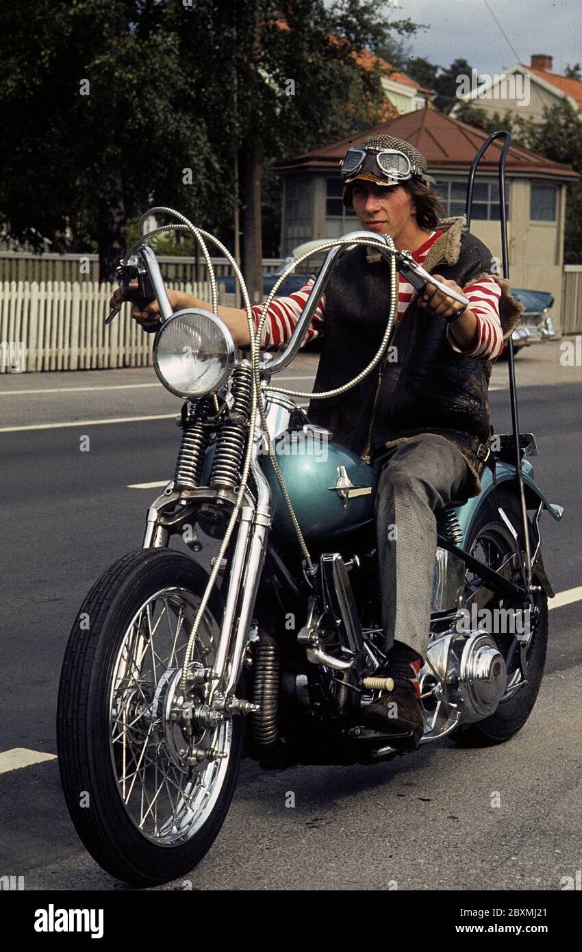 Dans les années 1960. Un jeune homme sur sa moto Harley Davidson. La loi de  port d'un casque de sécurité n'est pas encore en vigueur et à ce moment-là,  il était populaire