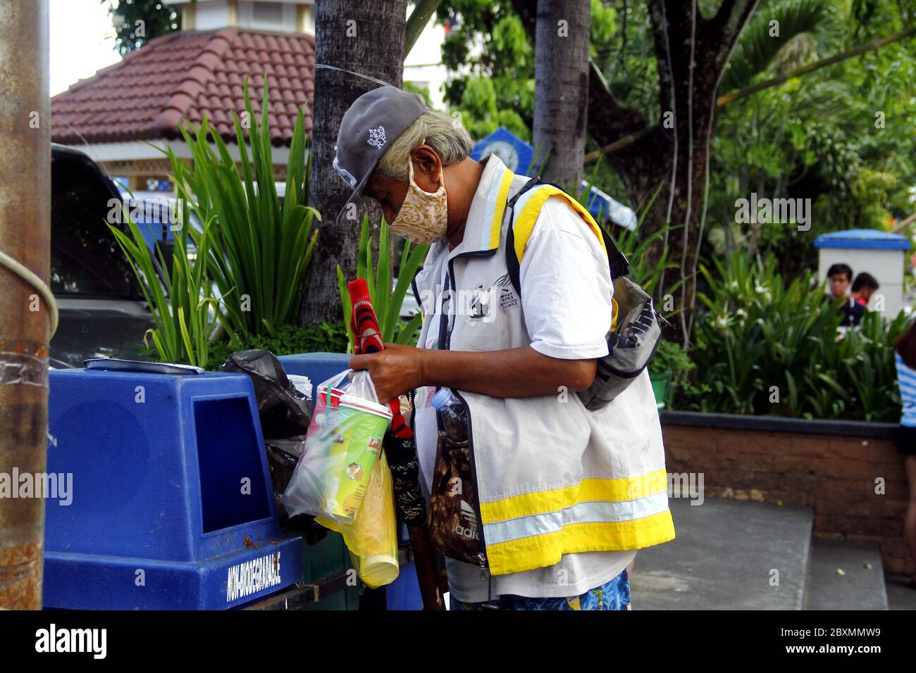 Antipolo City, Philippines - 1 juin 2020 : le collecteur passe par une poubelle pour rechercher des déchets recyclables. Banque D'Images