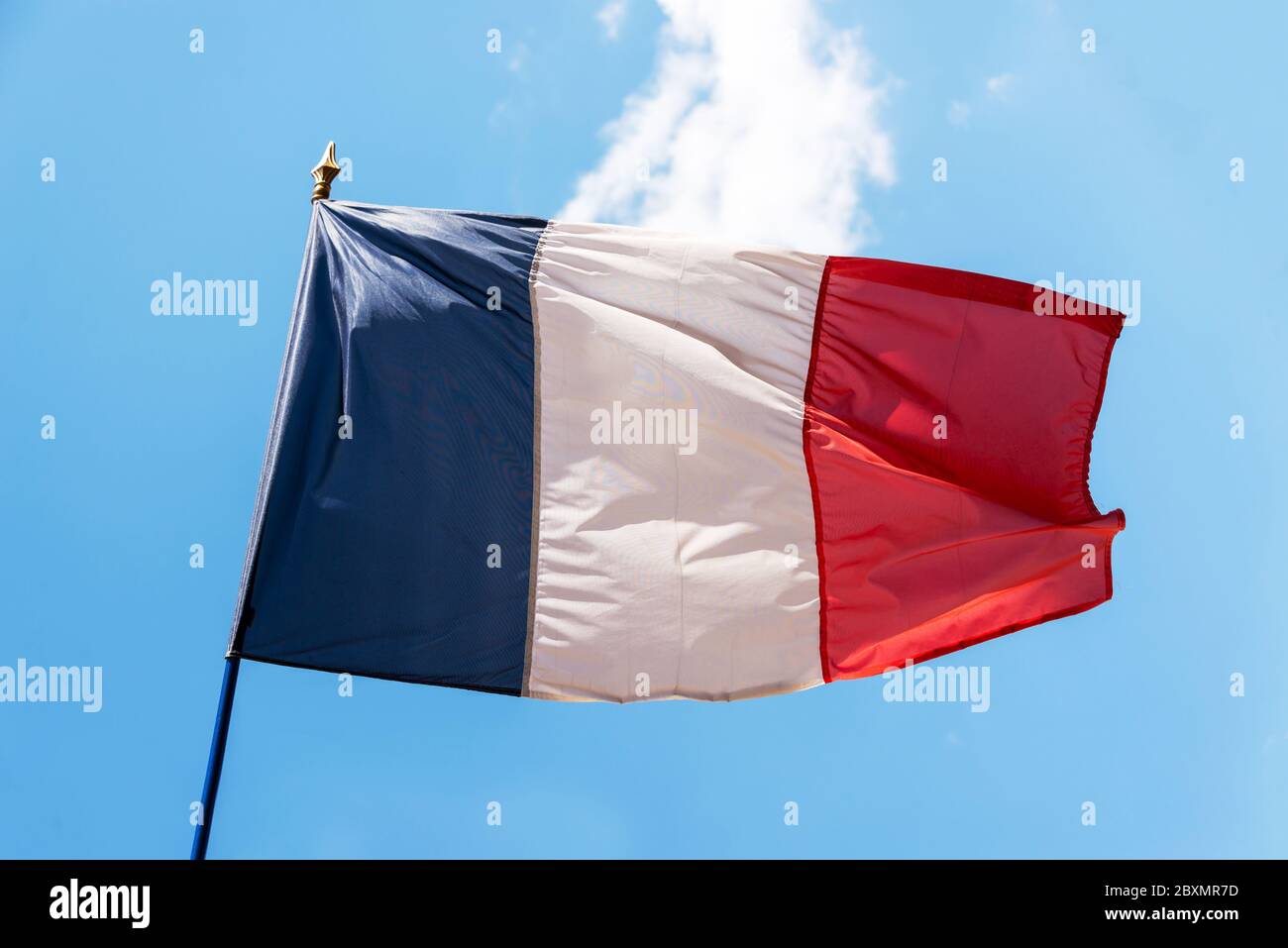 Véritable drapeau français sur un poteau contre ciel bleu Banque D'Images