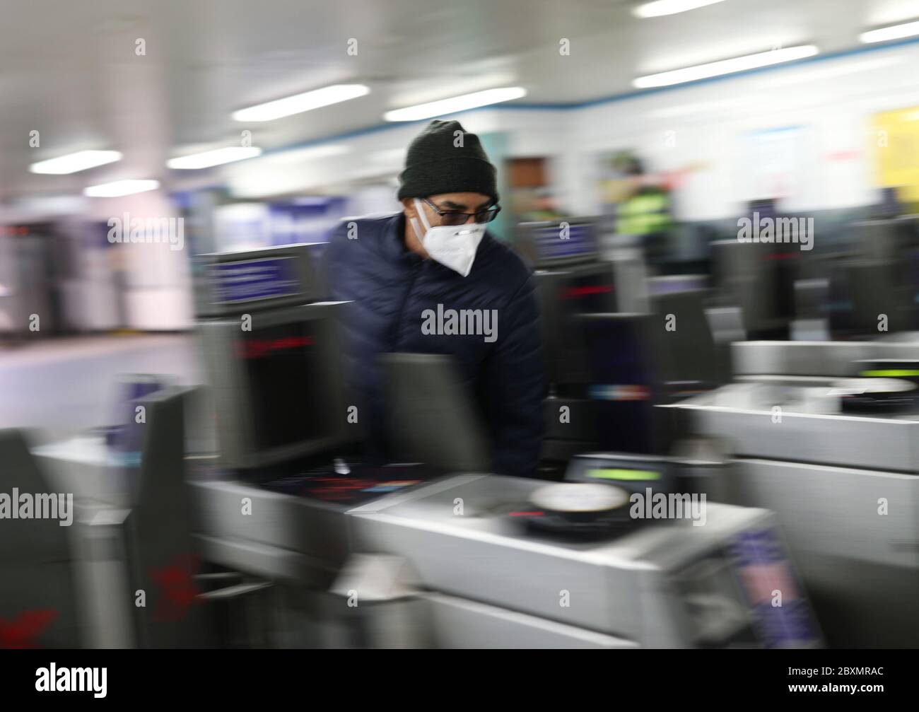 Un homme porte un masque facial lorsqu'il sort des barrières tarifaires de la station de métro Brixton, dans le sud de Londres. A partir de lundi, les revêtements doivent être portés pour toute la durée des trajets sur le réseau de transport public, dans le cadre des nouvelles mesures introduites par le gouvernement pour aider à stopper la propagation du coronavirus. Banque D'Images