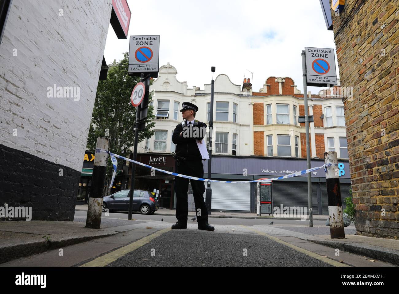La police sur les lieux de l'incident à Askew Road, Shepherd's Bush, dans l'ouest de Londres, alors qu'une enquête sur un meurtre a été lancée après qu'un homme ait été abattu. La victime, qui aurait été dans ses 20 ans, a été retrouvée avec des blessures par balle dans les premières heures de lundi. Banque D'Images