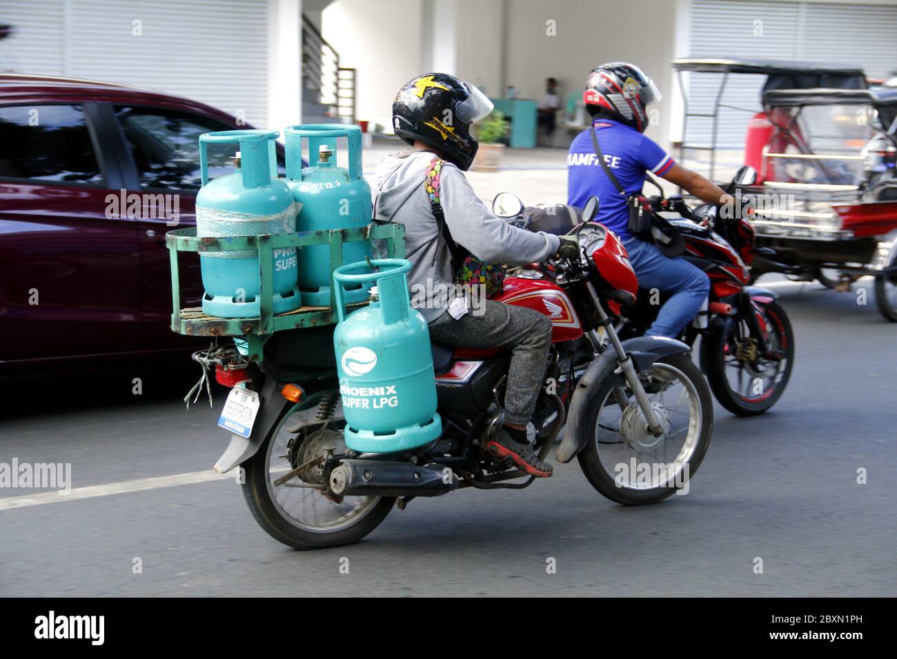 Antipolo City, Philippines - 1 juin 2020 : le pilote utilise une moto pour livrer plusieurs réservoirs de GPL ou de gaz de pétrole liquéfié à un client. Banque D'Images