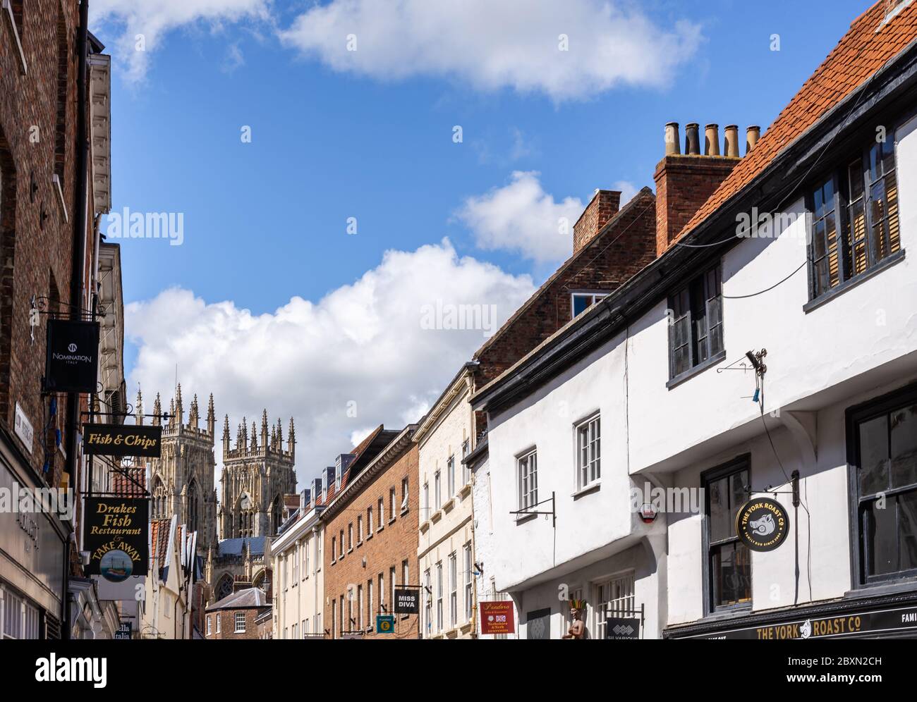 Dans Low Petergate York avec ses boutiques et les tours de la cathédrale de York dans l'arrière-plan Banque D'Images
