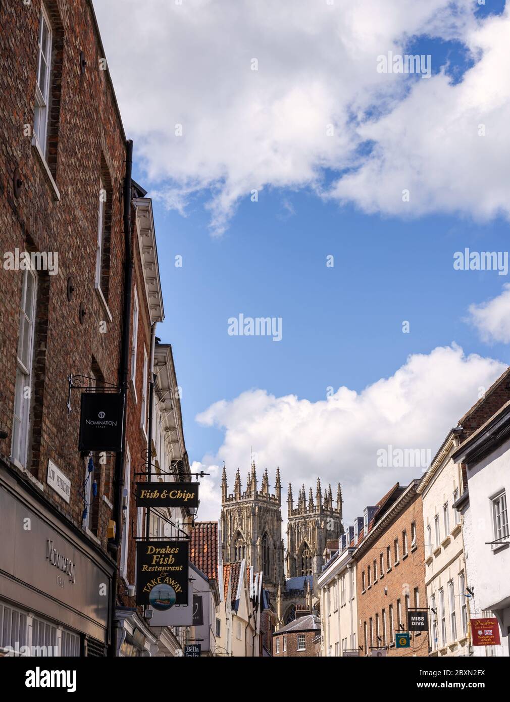 Dans Low Petergate York avec ses boutiques et les tours de la cathédrale de York dans l'arrière-plan Banque D'Images