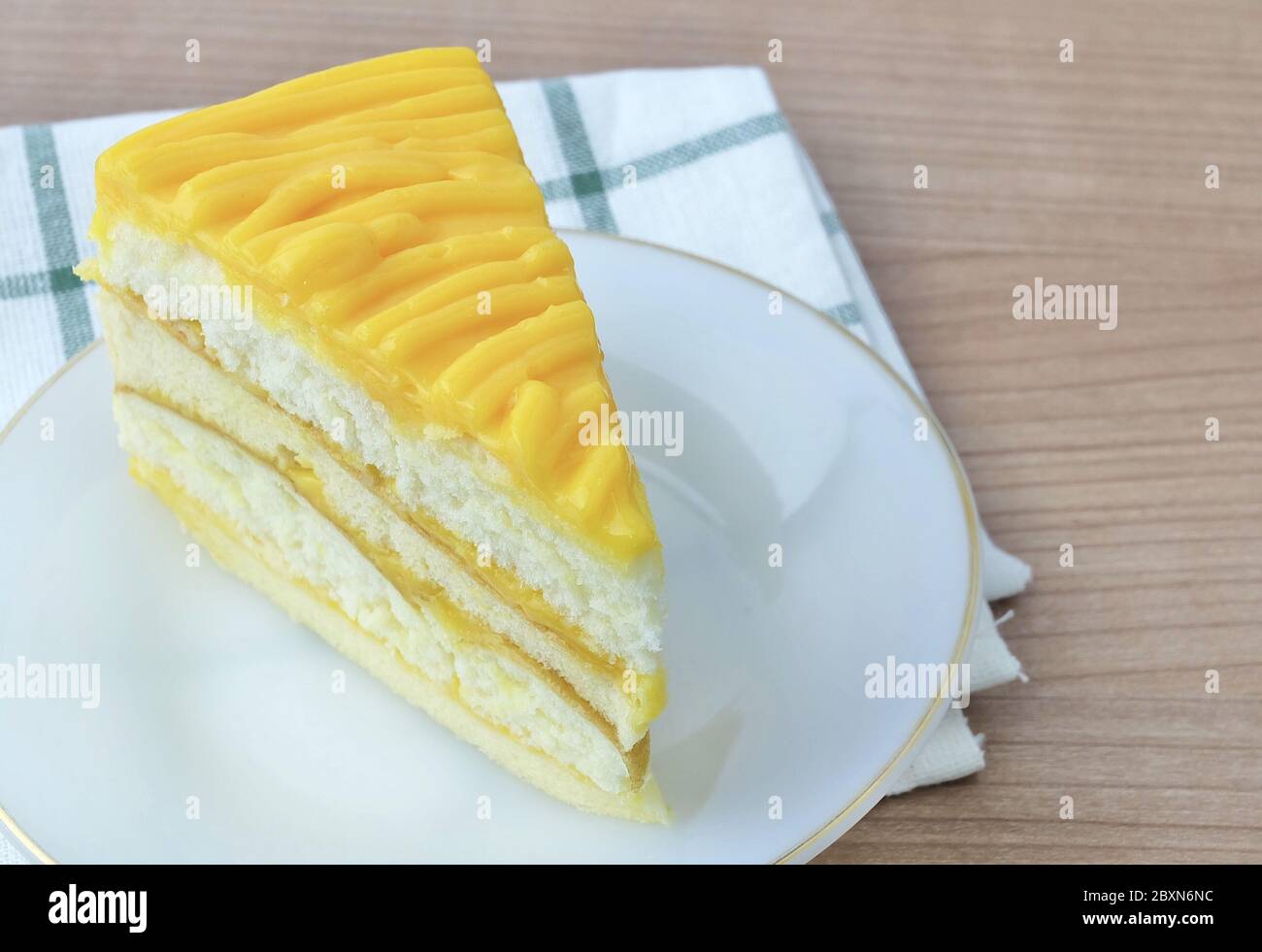 En-cas et dessert, UN morceau de gâteau de mangue fait avec du beurre, des œufs, du sucre, de la farine, de la poudre à pâte et des arômes recouverts de sauce mangue. Banque D'Images