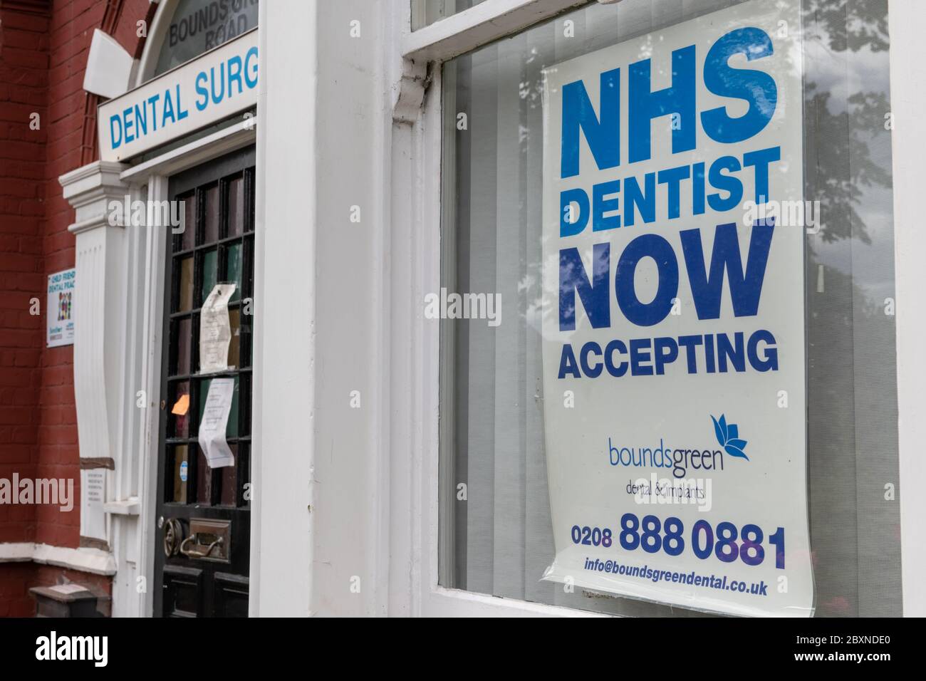 Affiche dans la fenêtre d'une pratique dentaire accueillant les patients du NHS. Banque D'Images