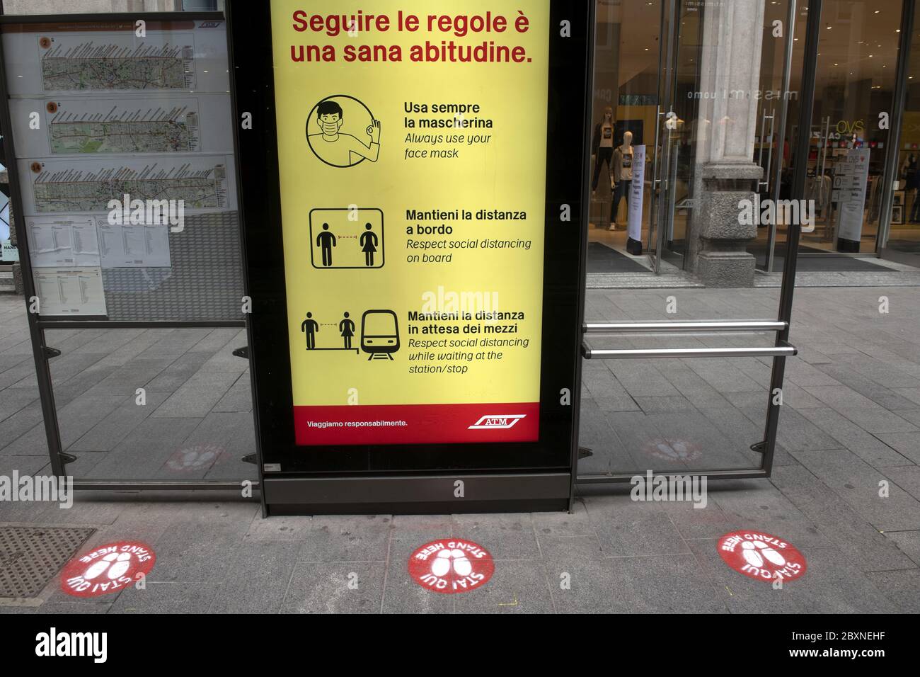 Station de tram avec des panneaux de distance sociale sur le sol pour la sécurité sanitaire pendant la crise Covid-19, à Milan, Italie. Banque D'Images