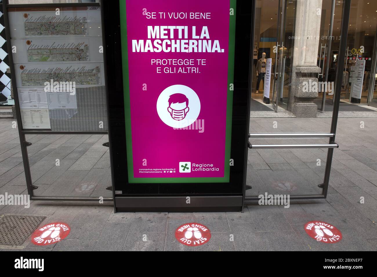 Station de tram avec des panneaux de distance sociale sur le sol pour la sécurité sanitaire pendant la crise Covid-19, à Milan, Italie. Banque D'Images