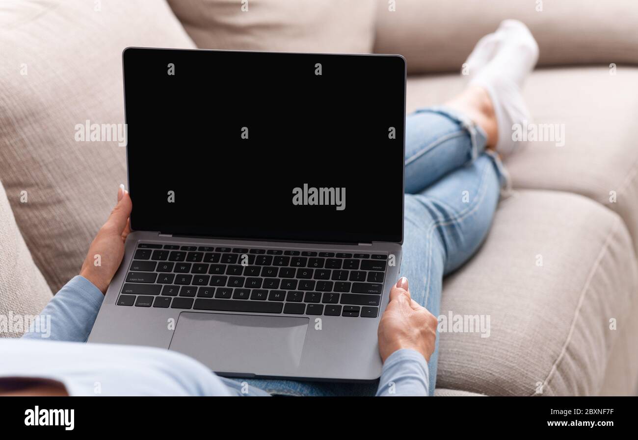 Travaillez facilement sur des appareils intelligents à la maison. Femme adulte tenant un ordinateur portable avec écran vierge Banque D'Images