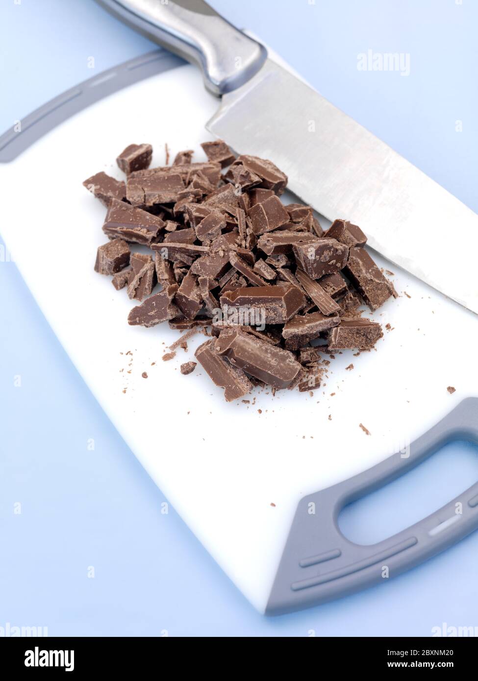 Haché Chocolat à cuire sur une planche à découper isolé sur un fond bleu  Photo Stock - Alamy