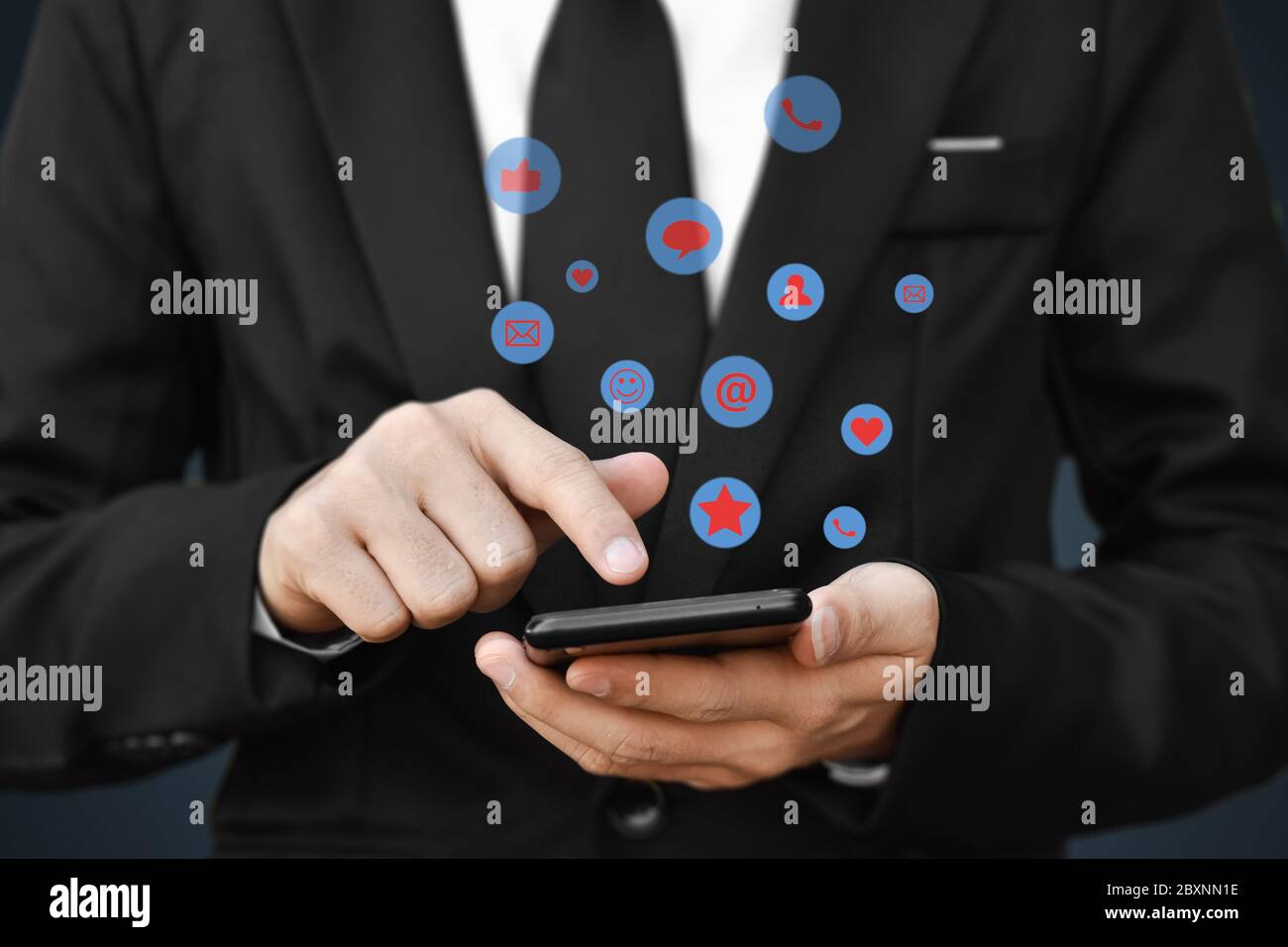 Gros plan des mains d'un homme d'affaires à l'aide d'un smartphone mobile avec icône de réseaux sociaux. Idée pour les affaires, le marketing en ligne et la technologie. Banque D'Images