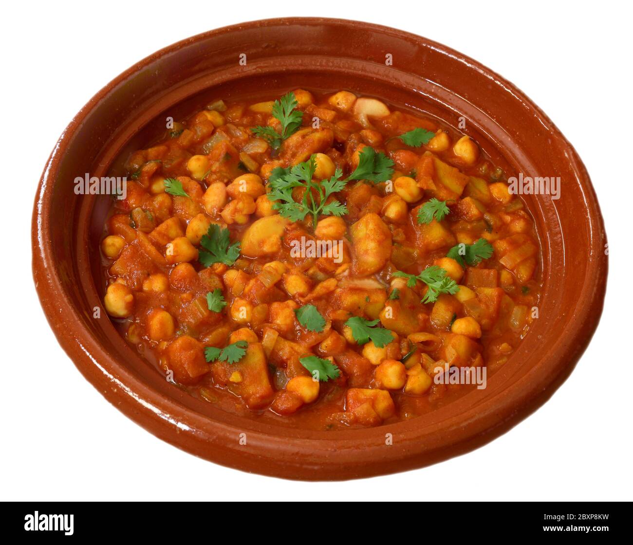 Chana Masala avec patates douces. Curry épicé de pois chiches végétariens dans un plat en faïence. Isolé sur fond blanc. Banque D'Images