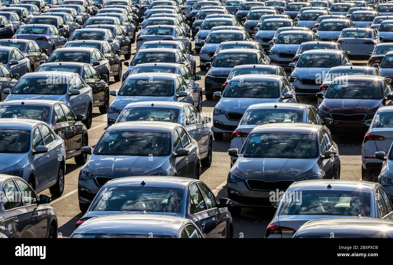 Rangées d'une nouvelle voiture garées dans un centre de distribution sur une usine de voitures par temps ensoleillé. Vue de dessus du stationnement en plein air. Banque D'Images