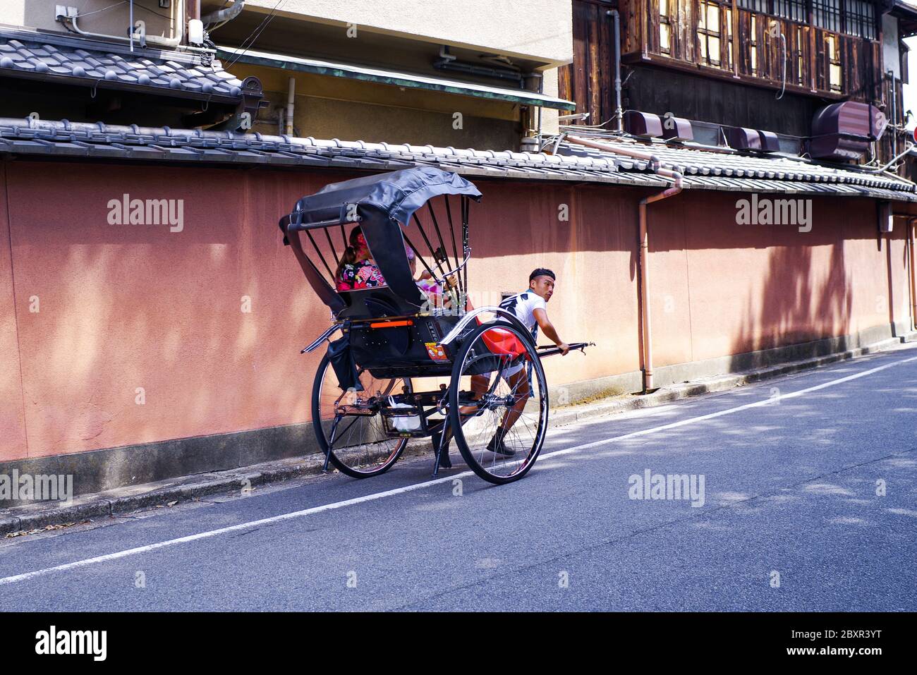 Japon, Kyoto. 2018. Les pousse-pousse sont populaires à Kyoto.Japon, Kyoto. 2018. Un pousse-pousse japonais fait une promenade en calèche dans la rue. Banque D'Images